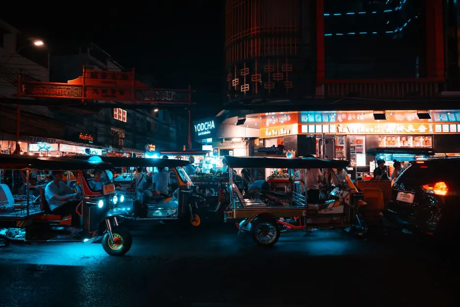 Tuk tuks y ambiente callejero nocturno en la animada ciudad de Bangkok, Tailandia.