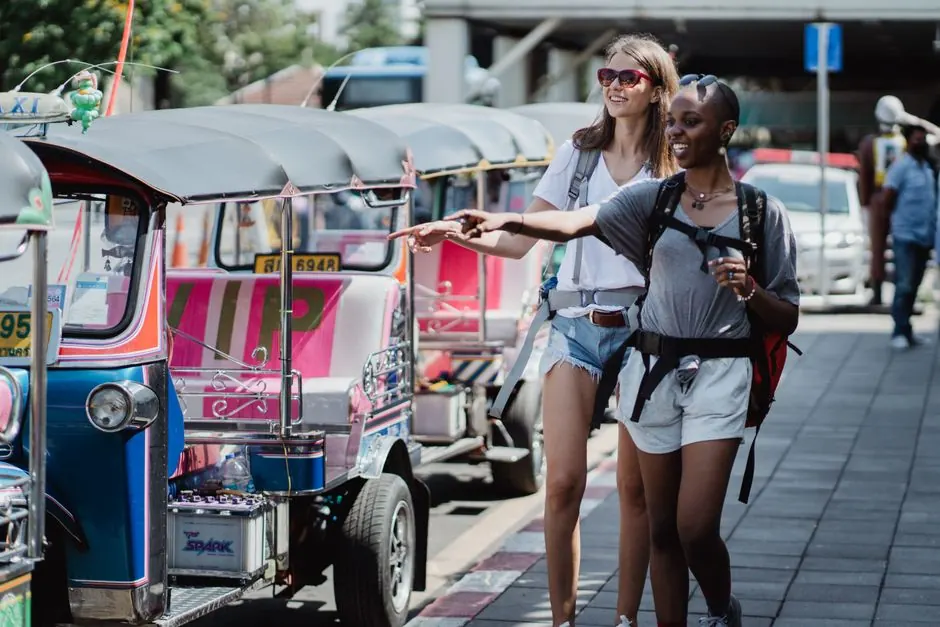 Dos mujeres explorando la ciudad en tuk tuk, disfrutando de un día de viaje y aventura.