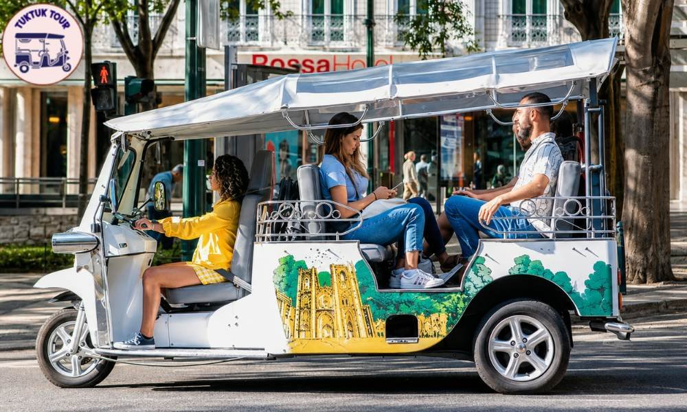 Travellers riding a shared electric tuk-tuk tour past historic landmarks in central Madrid